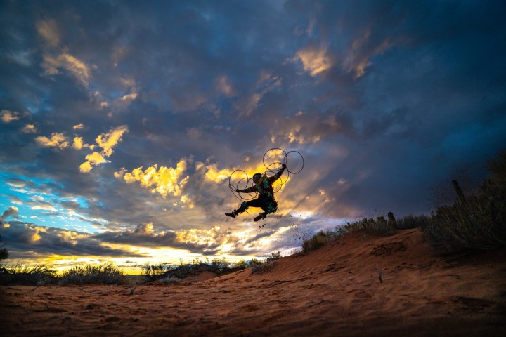 a man flying through the air on a cloudy day